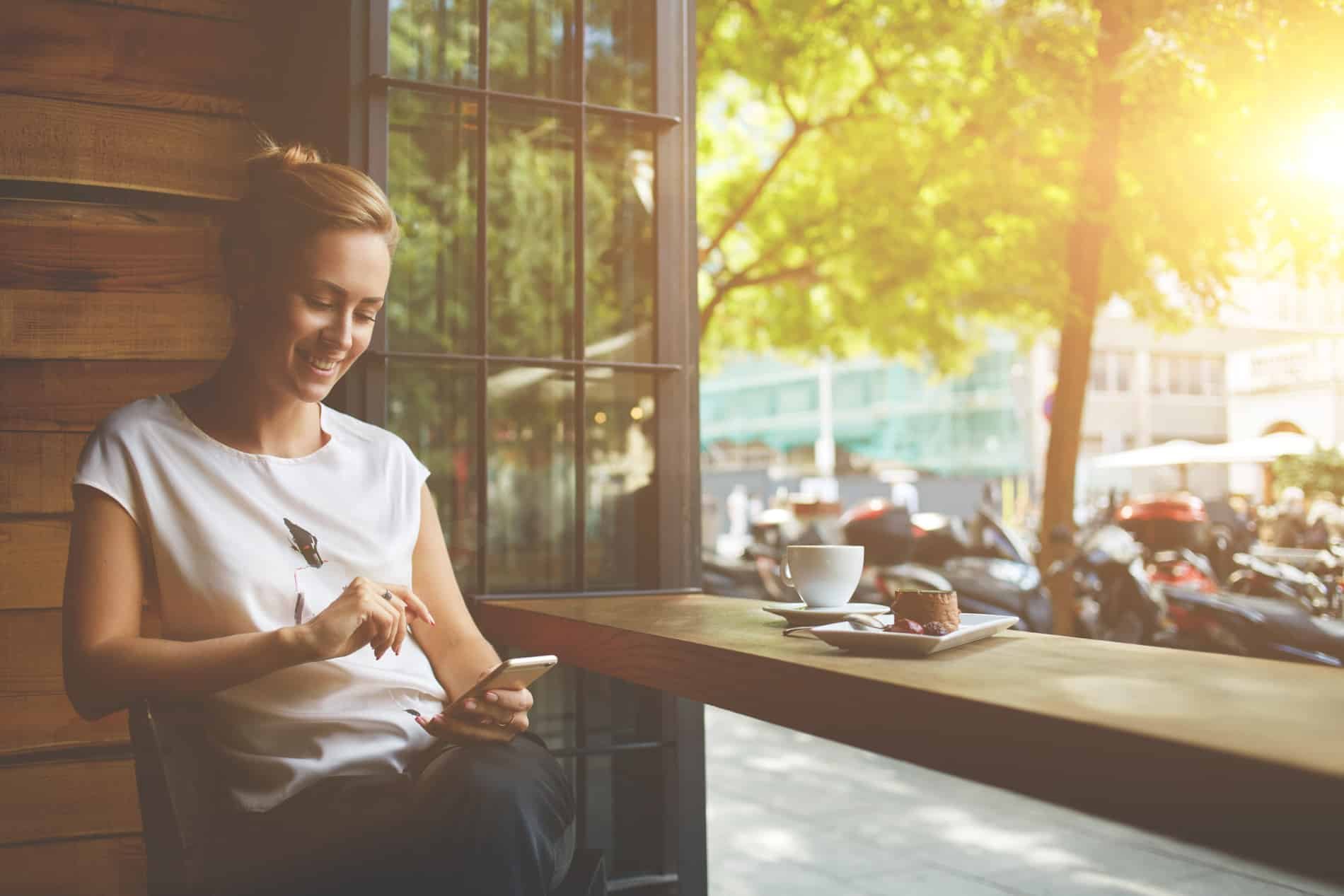 Gebärdensprachdolmetscherin mit Smartphone in einem Café